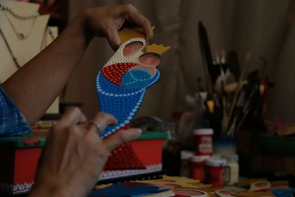 Artesana maracucha pinta en material de desecho a La Chinita