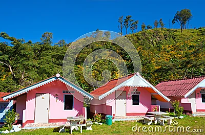 Casas rosadas dispuestas delante de una montaña.