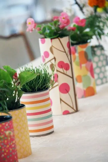Una mesa decorada con latas y flores - Paperblog
