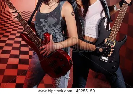 Parte de los cuerpos de dos mujeres tocando la guitarra eléctrica ...