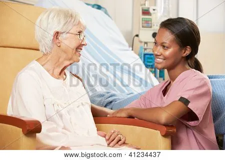 Enfermera hablando a paciente femenino Senior sentado en silla por ...