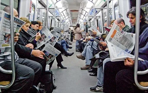 Extraños en un tren, pero leyendo el periódico |