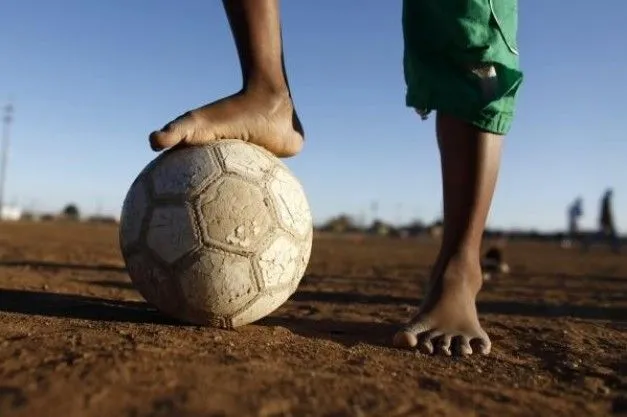 Foto - Un niño de medidas sobre una pelota de fútbol como él ...