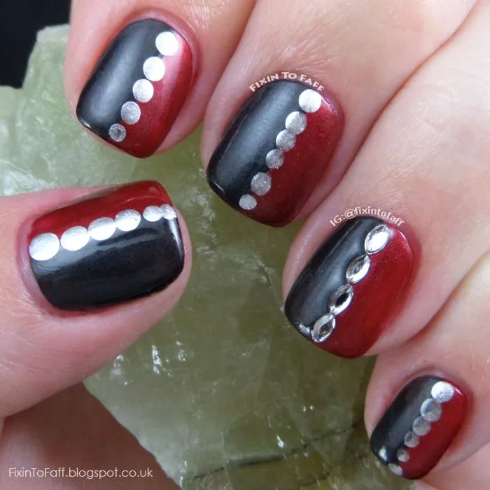 Hermosa manicura en negro y rojo, decoradas con una línea de tachuelas redondas en color plata.