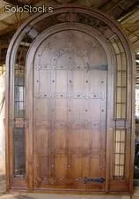 Esta hermosa puerta en madera es con una hoja de medio punto, es decir su parte superior en semicírculo.