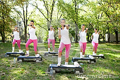 Seis mujeres que hacen los ejercicios al aire libre.
