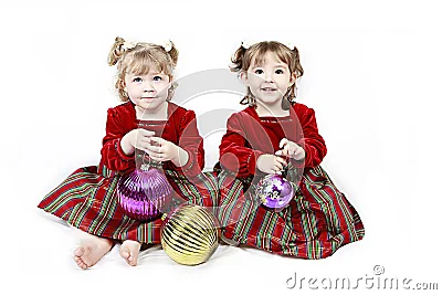 Dos niñas vestidas de rojo, adornos de navidad.