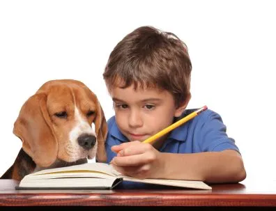 Niño estudiando acompañado de su perro - Portal Escuela