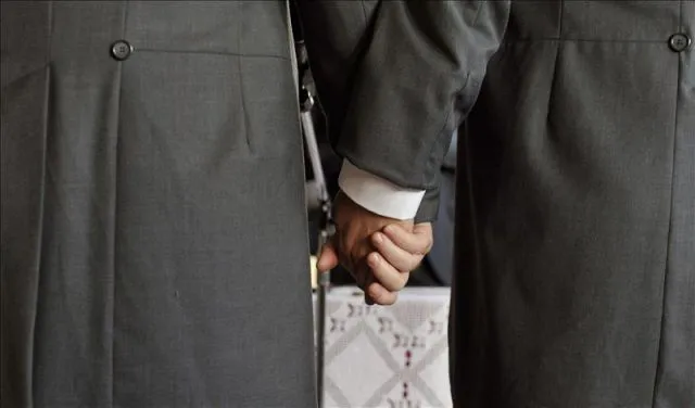 Dos novios agarrados de la mano durante la ceremonia de su ...