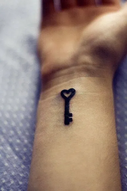 Pequeño tatuaje de una llave con forma de un corazón tatuado en la ...