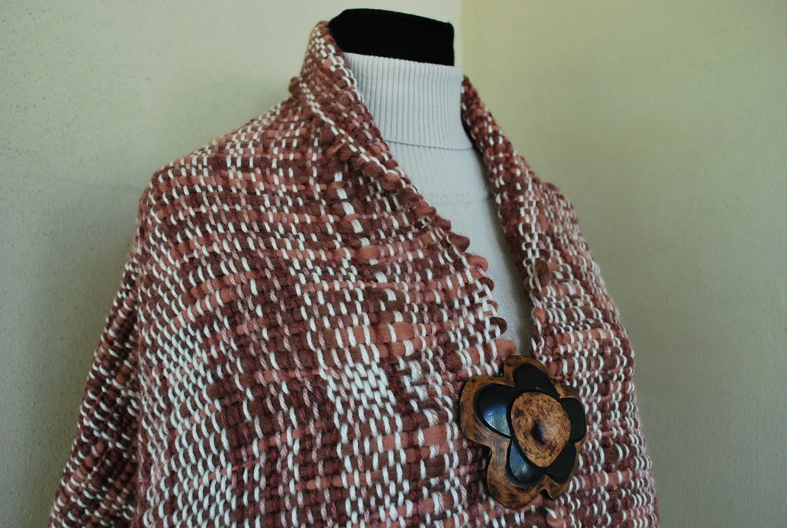 Ruana tipo poncho tejida en telar de peine en colores marrón y beige.