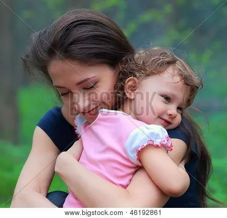 Sonriendo feliz madre y lindo niño niña abrazando al aire libre ...
