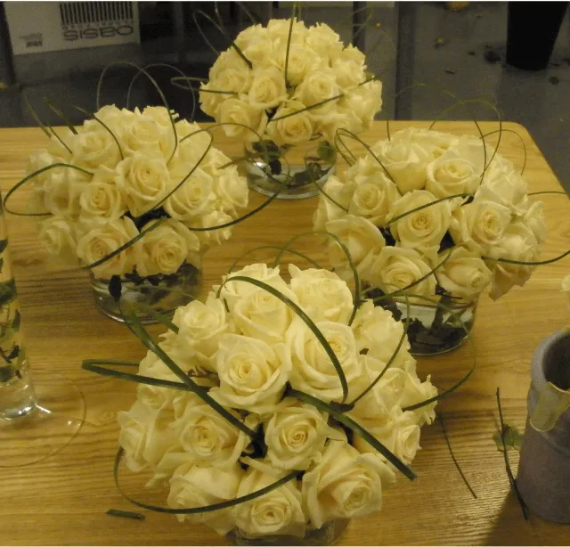 Wedding reception table arrangement with light yellow roses.PNG