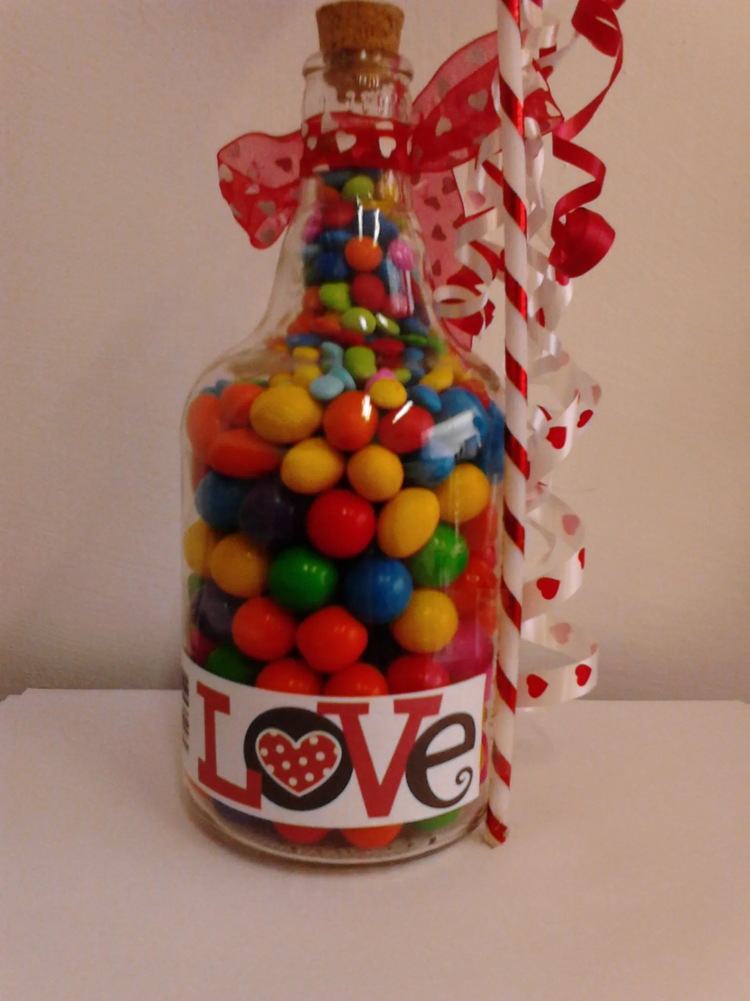 Botella decorada con etiqueta, listones y rellena de chicles ...