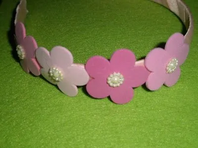 Cintillo rosado con flores en foami, y centros con perlitas Cintillo rosado con flores en foami, y centros con perlitas