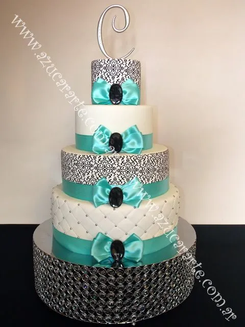 Elegante torta en 4 pisos, con moños en raso y terminación de dije ... Elegante torta en 4 pisos, con moños en raso y terminación de dije ...