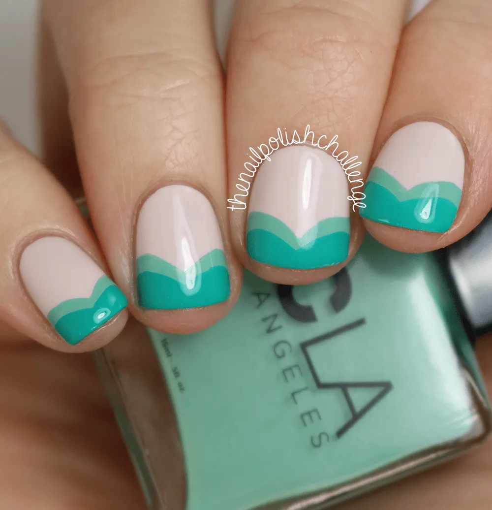 Fina manicura de uñas decoradas en beige, sus puntas adornadas con líneas onduladas en color verde esmeralda.