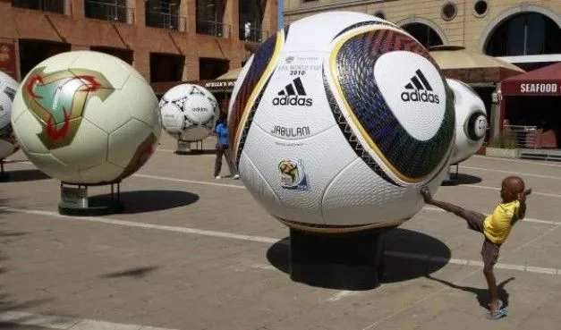 Foto - Un niño trata de patear una pelota gigante de parte de una ...