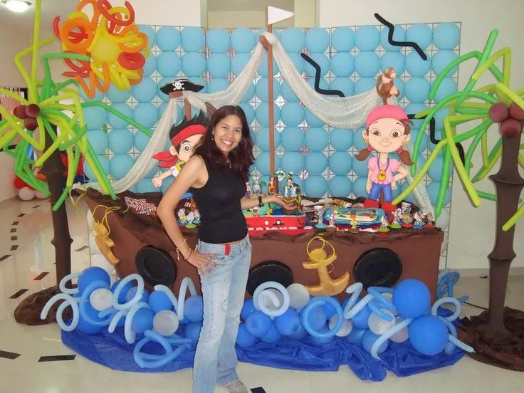 Mesón en forma de barco con pared de globos y palmeras ... Mesón en forma de barco con pared de globos y palmeras ...