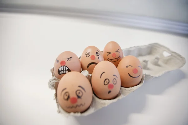 Seis huevos con rostros pintados en un cartón de huevos — Foto ... Seis huevos con rostros pintados en un cartón de huevos — Foto ...