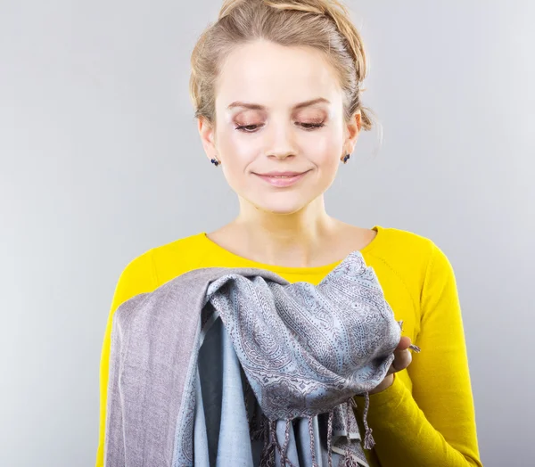 Joven rubia con ropa en hands.hostess piensa cómo guardar la ropa ... Joven rubia con ropa en hands.hostess piensa cómo guardar la ropa ...