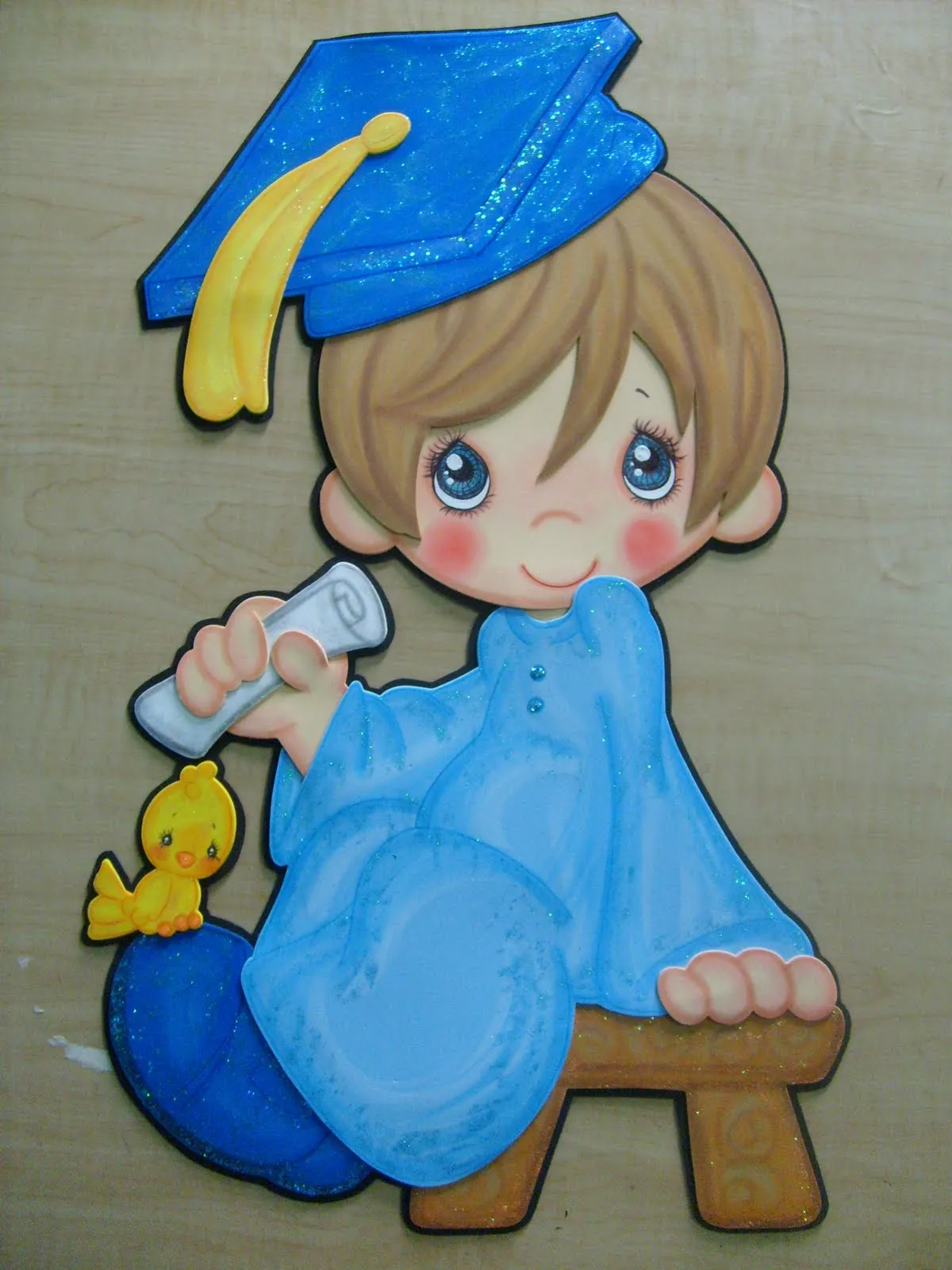 Fomiart: Julio: Niño con toga de graduación azul con diploma Fomiart: Julio: Niño con toga de graduación azul con diploma