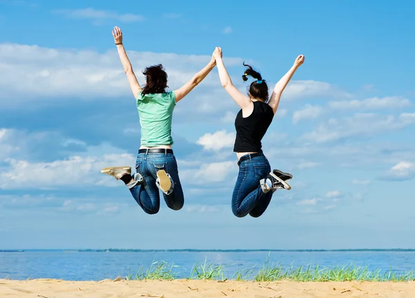 Dos mujeres felices saltando en la playa — Foto stock © DarkBird ... Dos mujeres felices saltando en la playa — Foto stock © DarkBird ...
