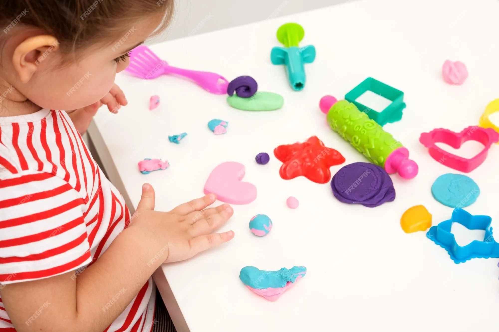 Niña esculpir corazón rosa de plastilina en mesa blanca juegos educativos para niños creatividad en el hogar jugar masa regalo para mamá amor infantil | Foto Premium
