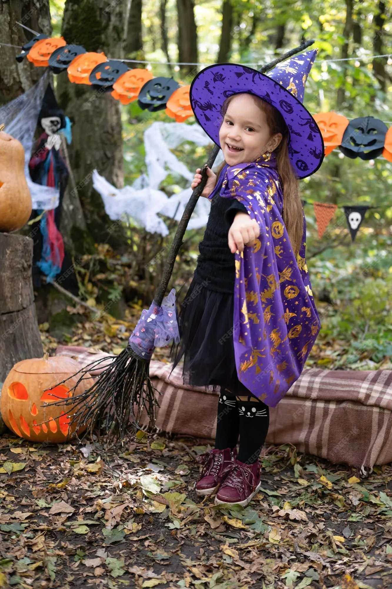 Niña feliz en disfraz de halloween y sombrero de bruja con escoba en decoración de halloween al aire libre | Foto Premium Niña feliz en disfraz de halloween y sombrero de bruja con escoba en decoración de halloween al aire libre | Foto Premium