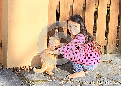 Niña que mima un gato.