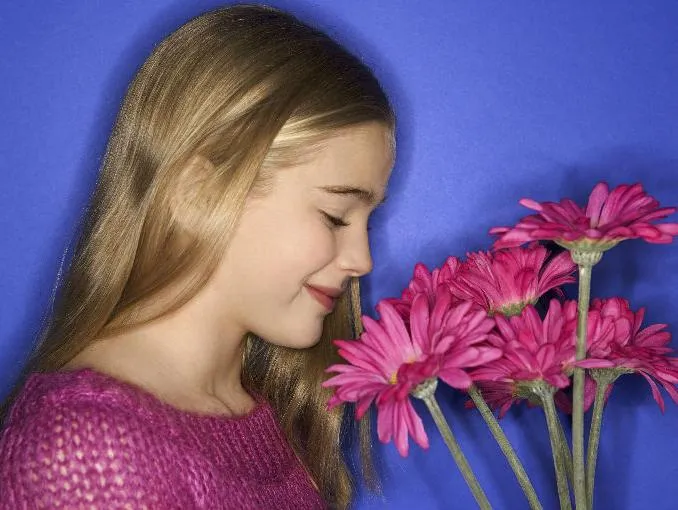 Una niña oliendo una rosa - Imagui