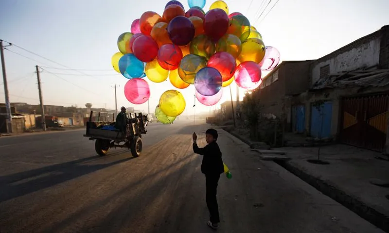 Un niño vende globos en una calle de Kabul,... Un niño vende globos en una calle de Kabul,...