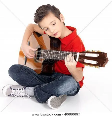 Niño sonriente es tocar la guitarra acústica Fotos stock e ...
