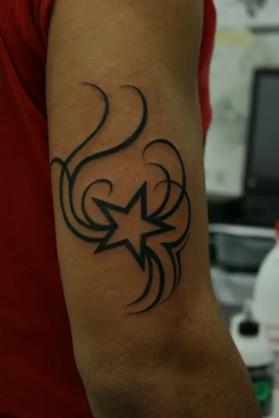 TATUAJE ESTRELLA CON TRIBAL ENCIMA DEL CODO