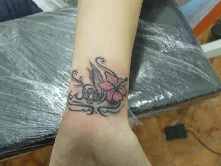 TATUAJE DE UNA PULSERA HECHA CON FLORES Y FINAS LINEAS TATUAJE DE UNA PULSERA HECHA CON FLORES Y FINAS LINEAS