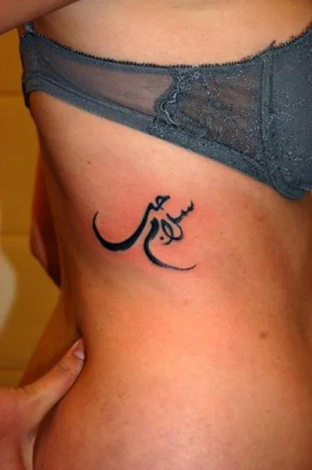 TATUAJE DE UNAS LETRAS ÁRABES EN EL COSTADO