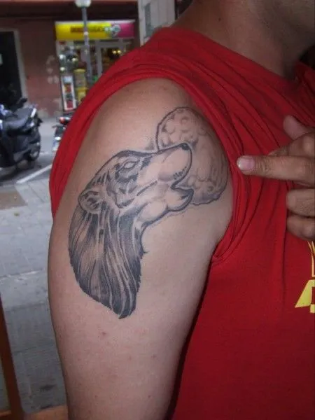 TATUAJE DE UN LOBO AULLANDO A LA LUNA