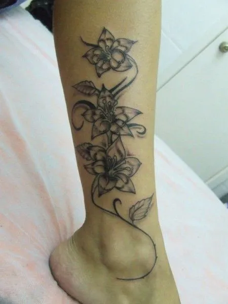 TATUAJE DE DOS GRANDES FLORES EN EL MUSLO DE UNA MUJER TATUAJE DE DOS GRANDES FLORES EN EL MUSLO DE UNA MUJER