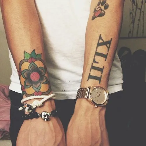 Pequeño tatuaje en los antebrazos de una flor, una fecha en ...