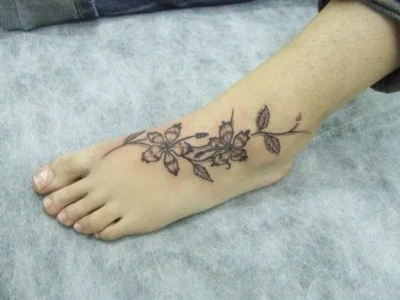 TATUAJE DE UN NOMBRE EN EL PIE CON UNA FLOR TATUAJE DE UN NOMBRE EN EL PIE CON UNA FLOR