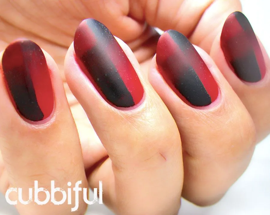 Uñas decoradas con diseños en rojo y negro.
