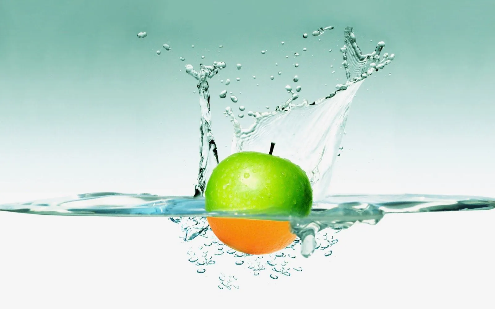wallpapernarium: Una manzana verde que cae al agua volviéndose naranja